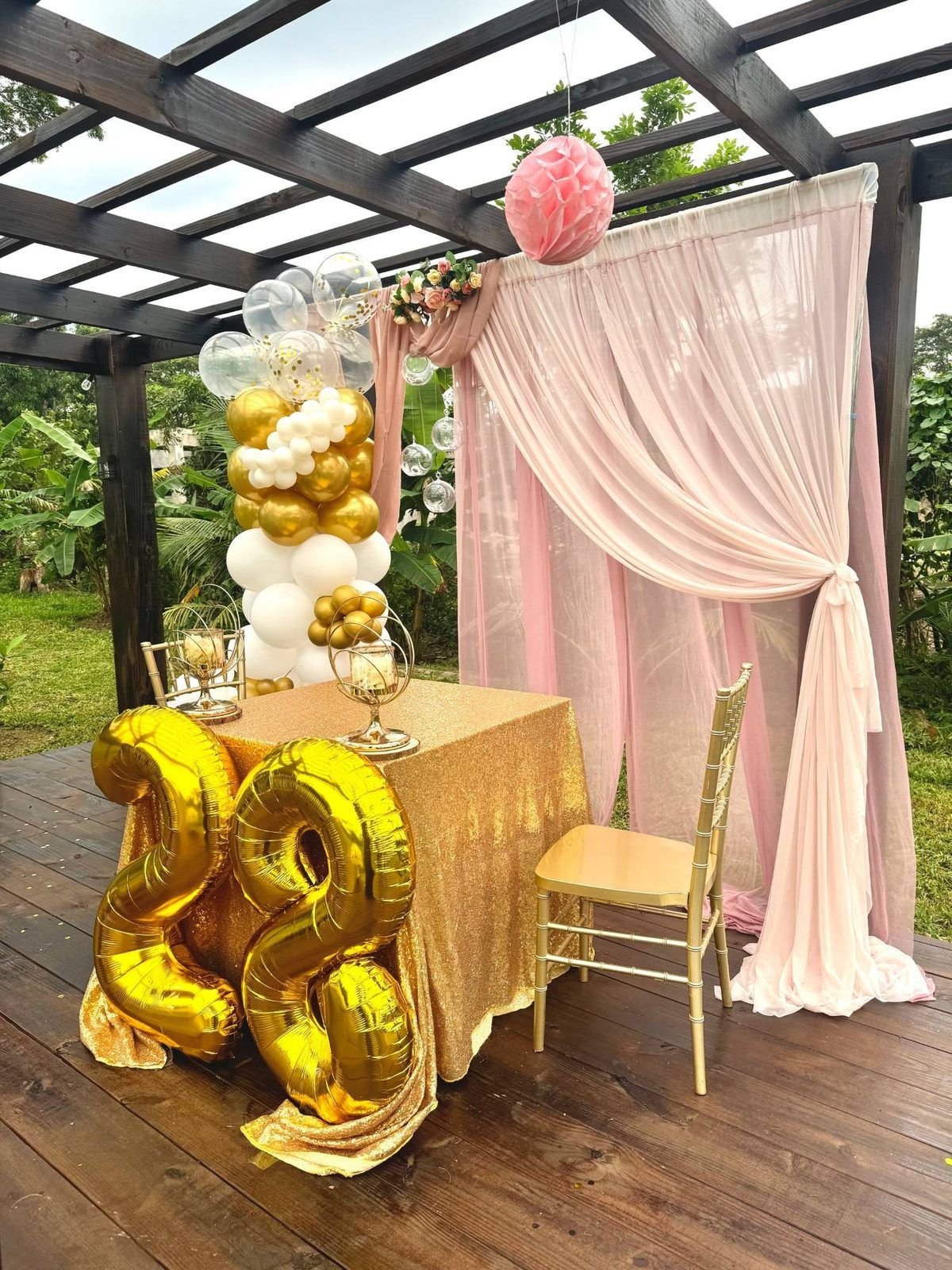 Gold 28th birthday table with pink drapes