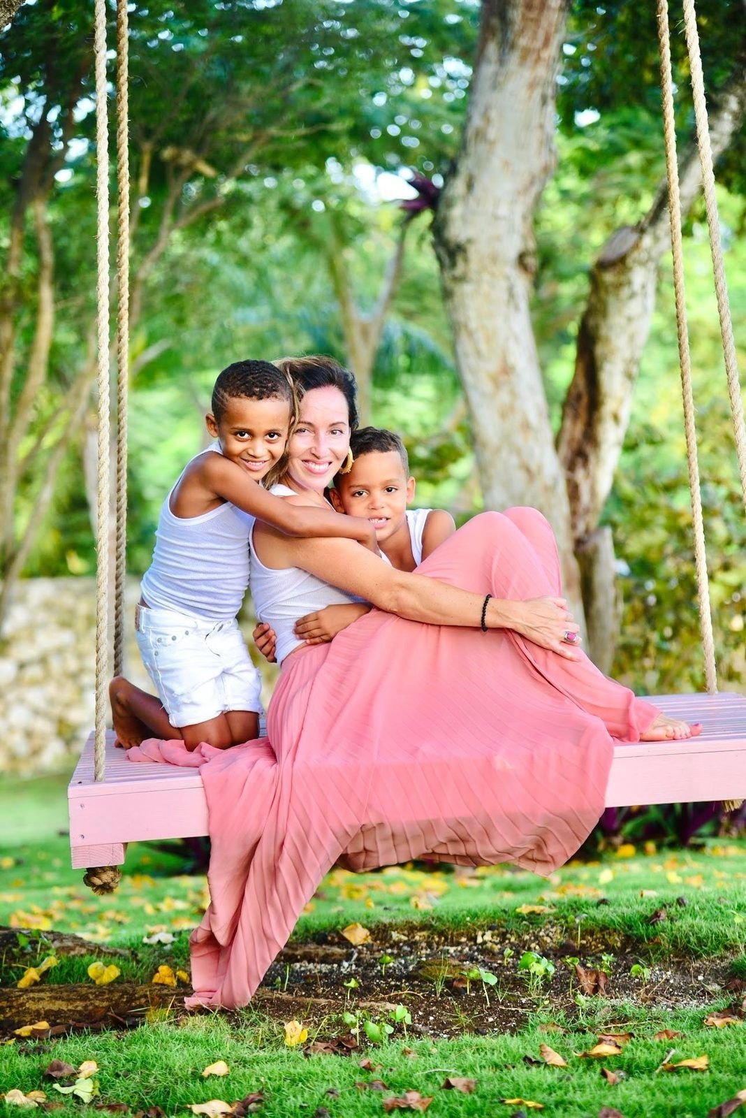 Mother and sons on the pink garden swing