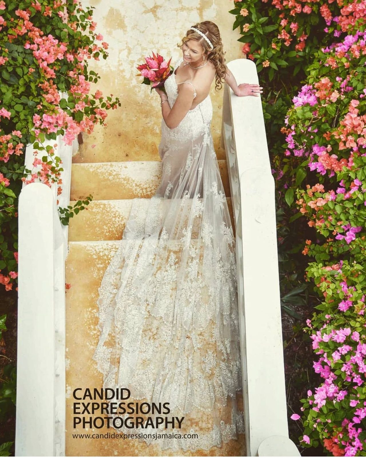 Bride on a staircase framed by bougainvillea