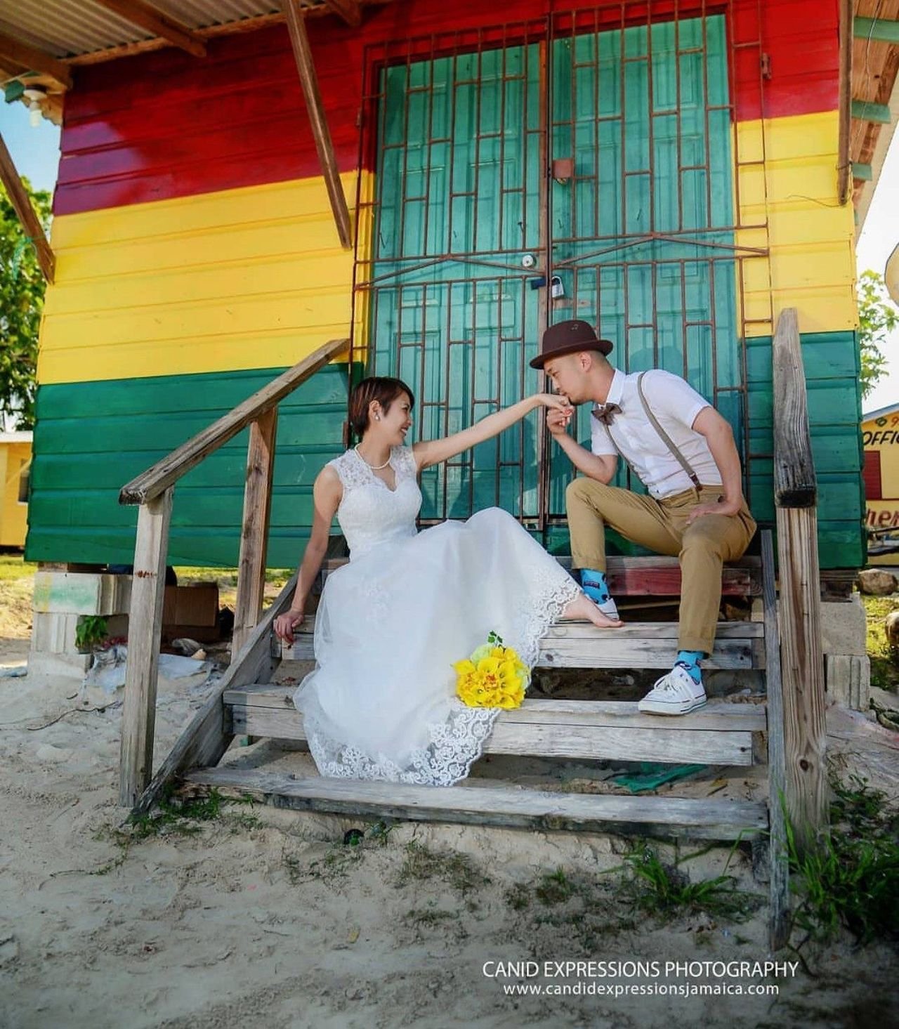 Groom kissing the bride's hand on colorful painted steps